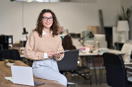Senhora sentada em uma mesa a segurar uma tablet