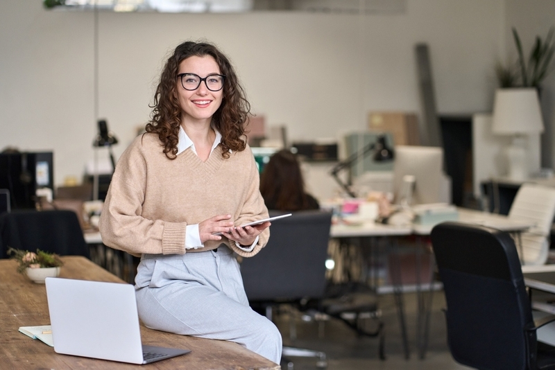 Senhora sentada em uma mesa a segurar uma tablet